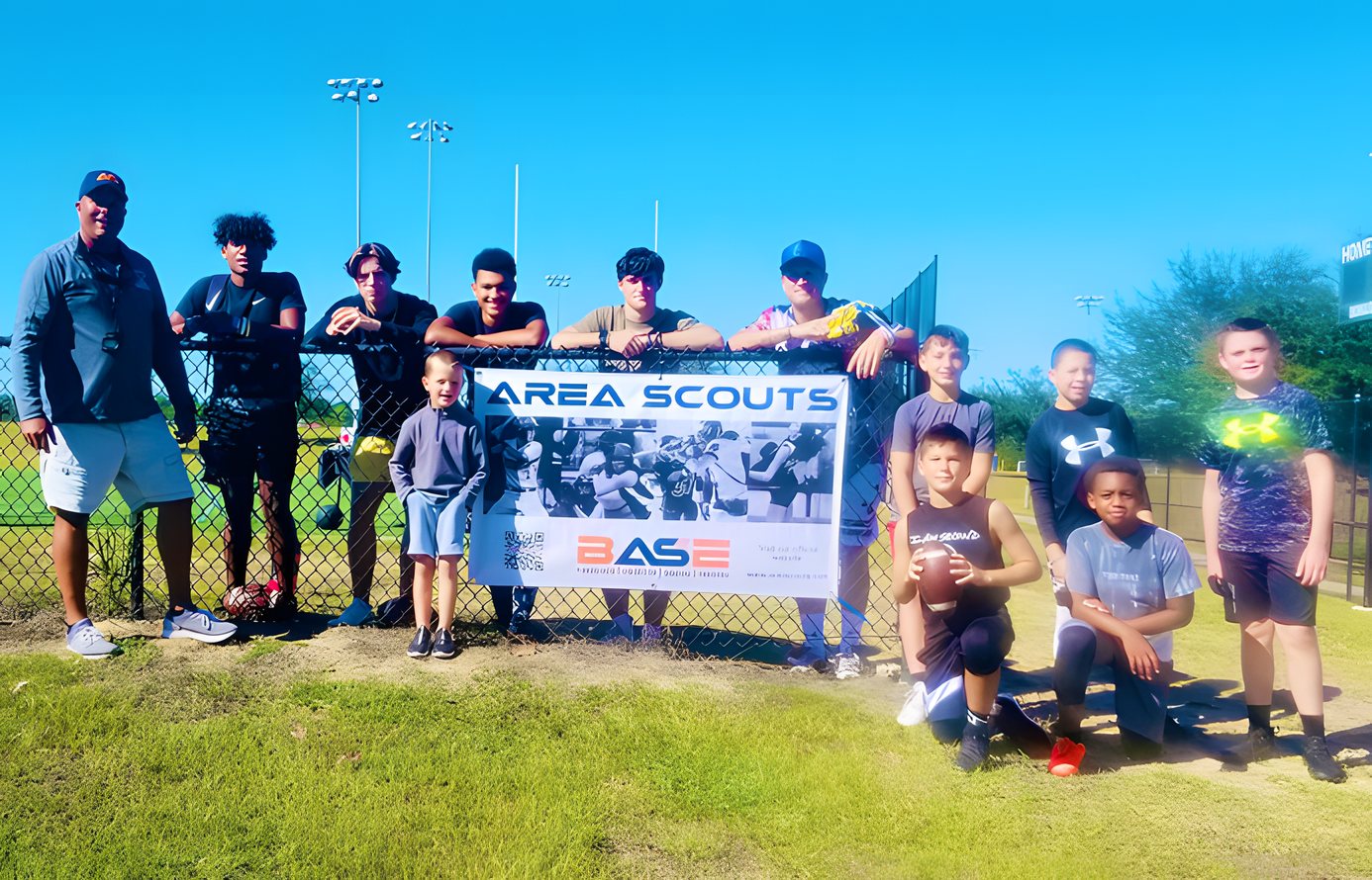 Youth athletes and coaches with the Area Scouts B.A.S.E. banner at a local field
