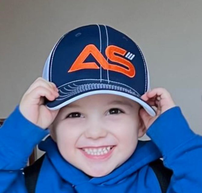 Smiling young child wearing an Area Scouts cap